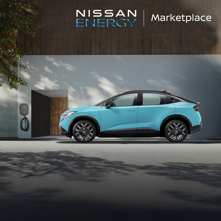 A light blue Nissan Ariya EV is parked outside a modern house with an EV charger. Nissan Energy Marketplace logo.